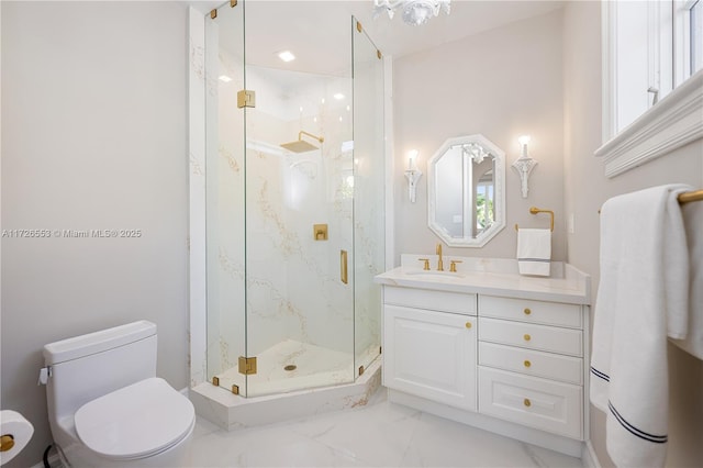 bathroom featuring vanity, toilet, and a shower with door