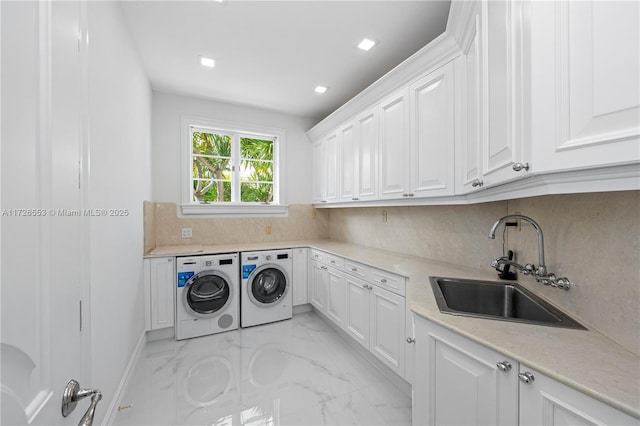 washroom featuring washer and dryer, sink, and cabinets