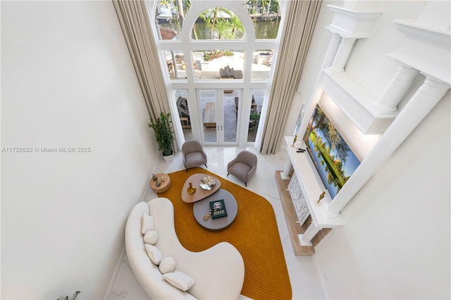 living room with a water view and a towering ceiling