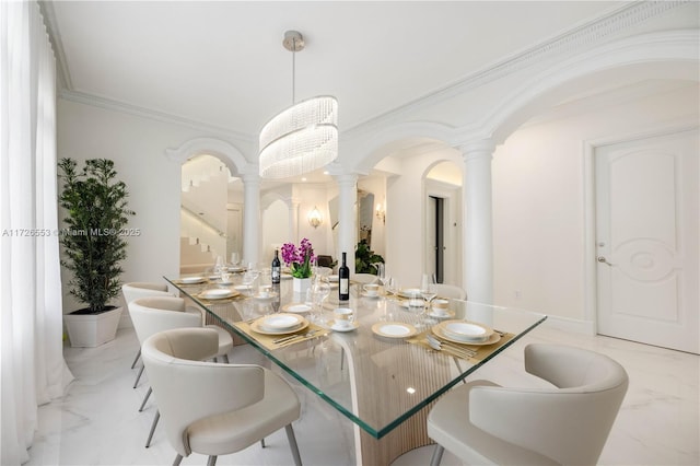 dining area featuring ornamental molding, decorative columns, and a chandelier