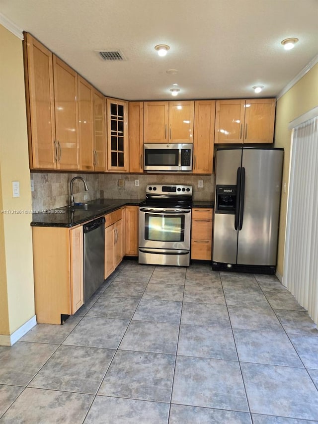 kitchen with sink, decorative backsplash, ornamental molding, and appliances with stainless steel finishes