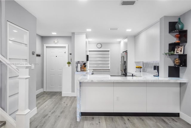 kitchen featuring white cabinetry, light hardwood / wood-style flooring, and kitchen peninsula