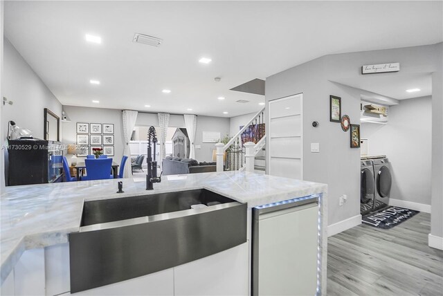 kitchen with backsplash, stainless steel appliances, light wood-type flooring, and white cabinets