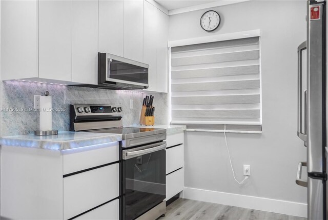 kitchen featuring white cabinets, electric range, sink, and dishwasher