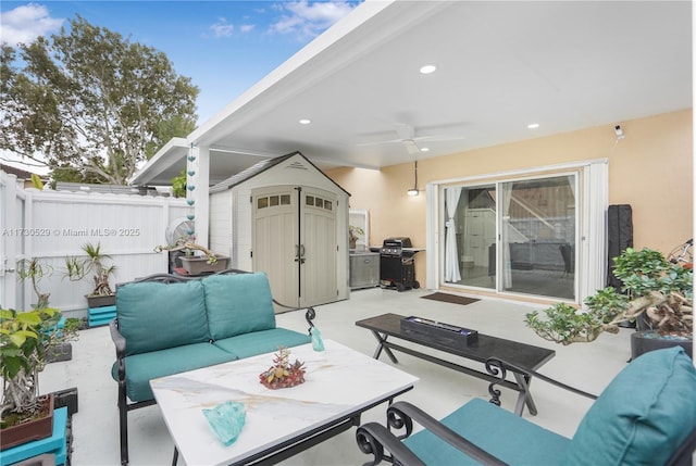 view of patio featuring ceiling fan, an outdoor living space, a storage unit, and a grill