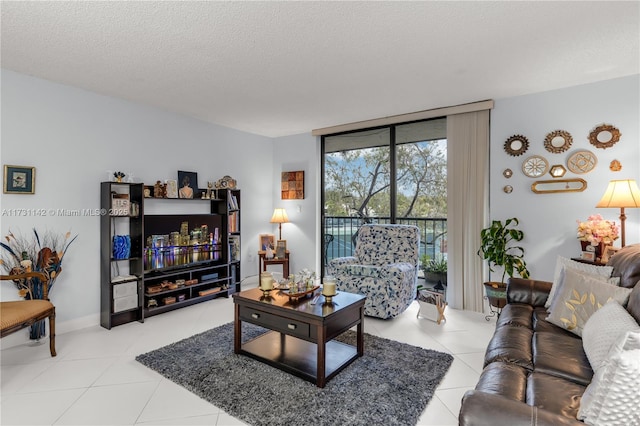 living room with expansive windows, tile patterned floors, and a textured ceiling