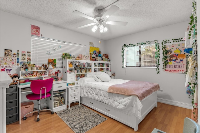 bedroom featuring hardwood / wood-style floors, a textured ceiling, and ceiling fan