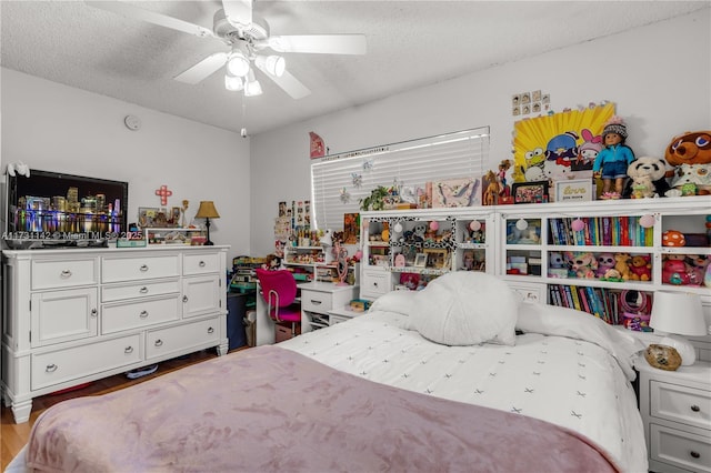 bedroom featuring ceiling fan, wood-type flooring, and a textured ceiling