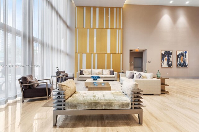 living room featuring a wall of windows, light hardwood / wood-style flooring, and a high ceiling