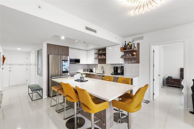 kitchen featuring appliances with stainless steel finishes, a breakfast bar, sink, and white cabinets