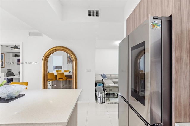 kitchen with light tile patterned floors and stainless steel refrigerator