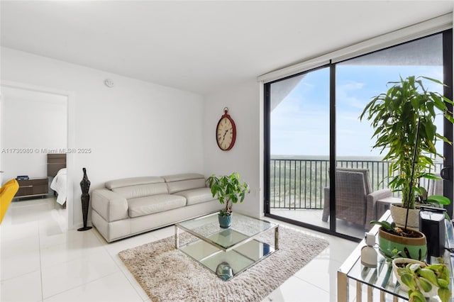 living room with floor to ceiling windows, a water view, and tile patterned floors