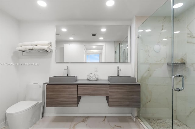 bathroom with a shower with door, vanity, and toilet