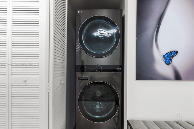 clothes washing area featuring stacked washer / drying machine