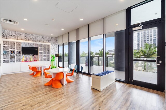 gym featuring a wall of windows and a drop ceiling