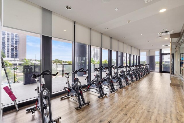 exercise room featuring expansive windows and hardwood / wood-style floors