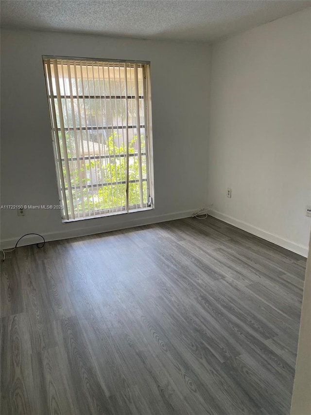 unfurnished room featuring hardwood / wood-style floors and a textured ceiling