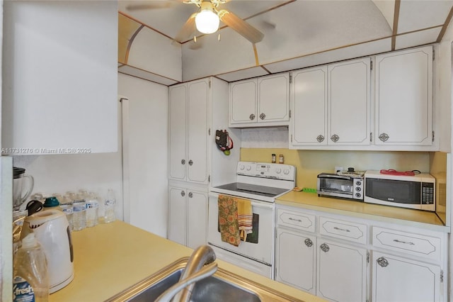 kitchen with a paneled ceiling, white cabinets, ceiling fan, and electric stove