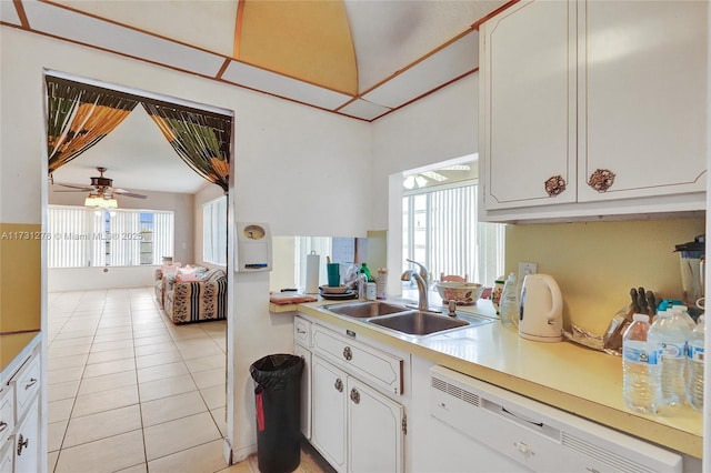 kitchen featuring white cabinetry, sink, light tile patterned flooring, and white dishwasher