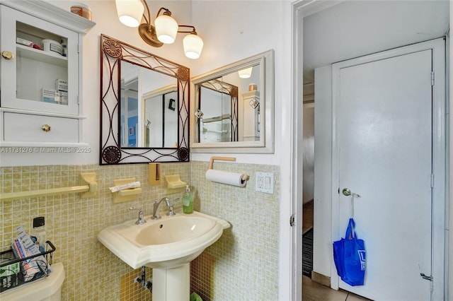 bathroom featuring tile walls, sink, tile patterned flooring, and toilet