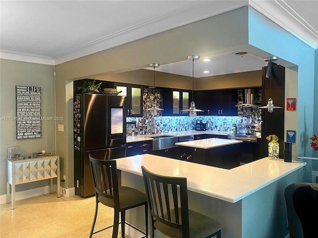 kitchen featuring backsplash, decorative light fixtures, a breakfast bar, and black fridge