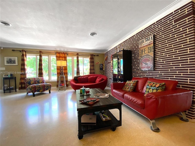 living room with ornamental molding, brick wall, and a textured ceiling