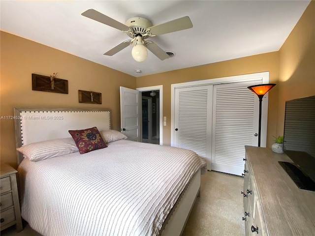 carpeted bedroom featuring ceiling fan and a closet