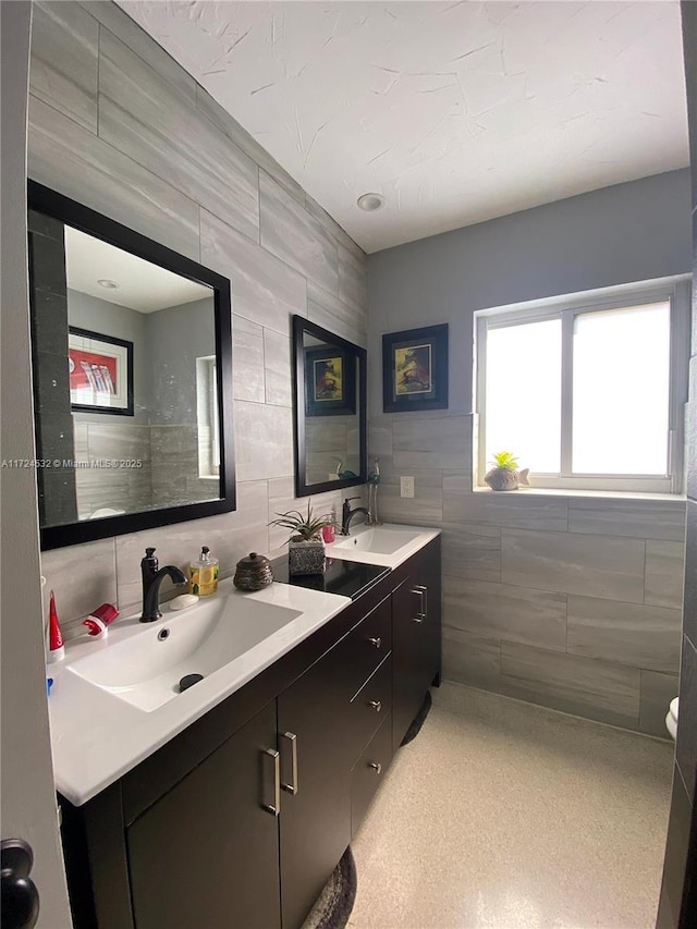 bathroom featuring tasteful backsplash, vanity, and tile walls