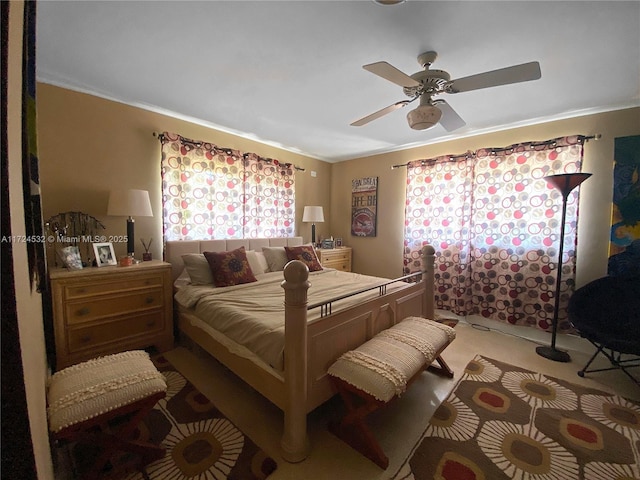 carpeted bedroom featuring crown molding and ceiling fan