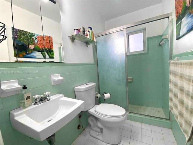 bathroom with toilet, sink, tile patterned floors, and walk in shower