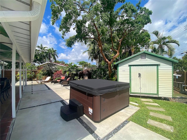 view of patio / terrace with a hot tub and a storage unit