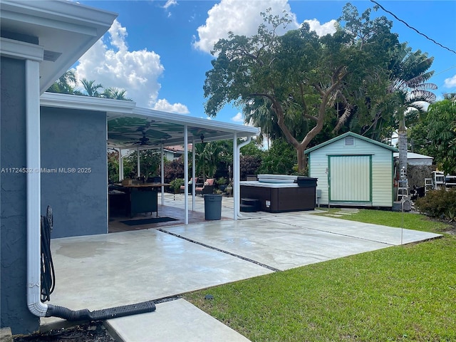 view of patio featuring a hot tub, ceiling fan, and a storage shed