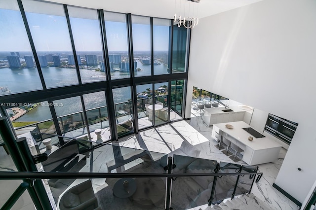 18555 Collins Ave Unit 4203, Sunny Isles Beach, FL 33160 - stairs with floor to ceiling windows, a water view, marble tiled flooring, a view of city, and a chandelier