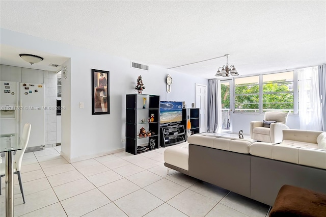 living room featuring light tile patterned flooring, an inviting chandelier, and a textured ceiling