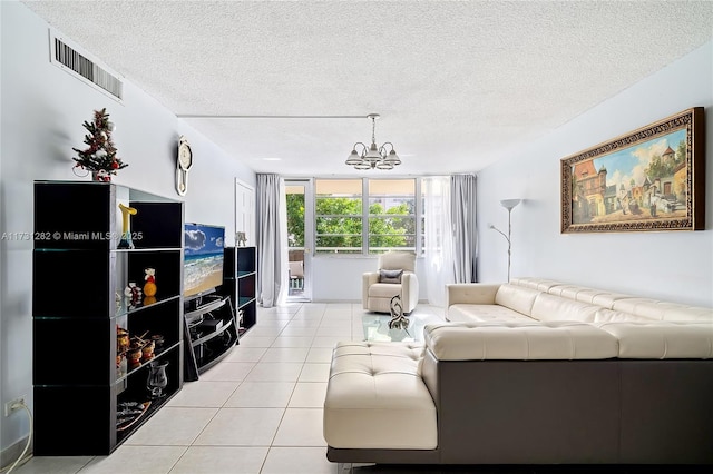 tiled living room featuring a notable chandelier and a textured ceiling