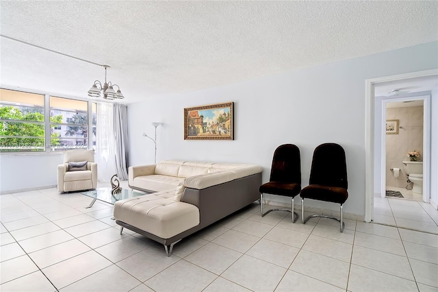 living room with a chandelier, light tile patterned floors, and a textured ceiling