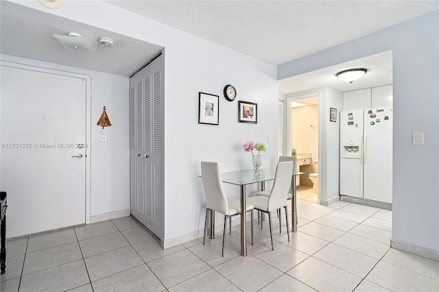 tiled dining room with a textured ceiling