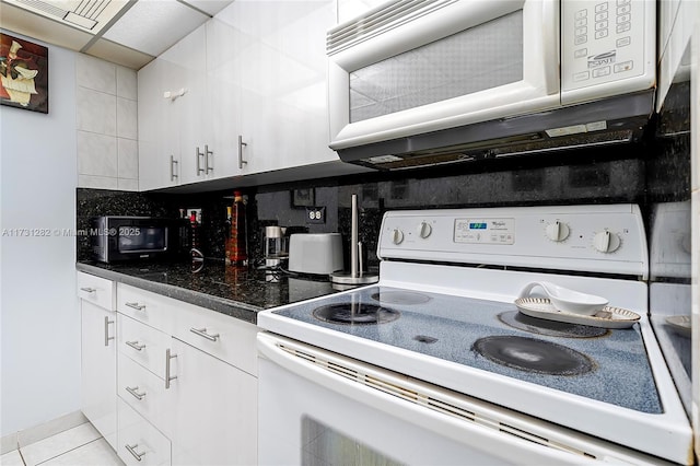 kitchen with tasteful backsplash, white appliances, white cabinets, and light tile patterned flooring