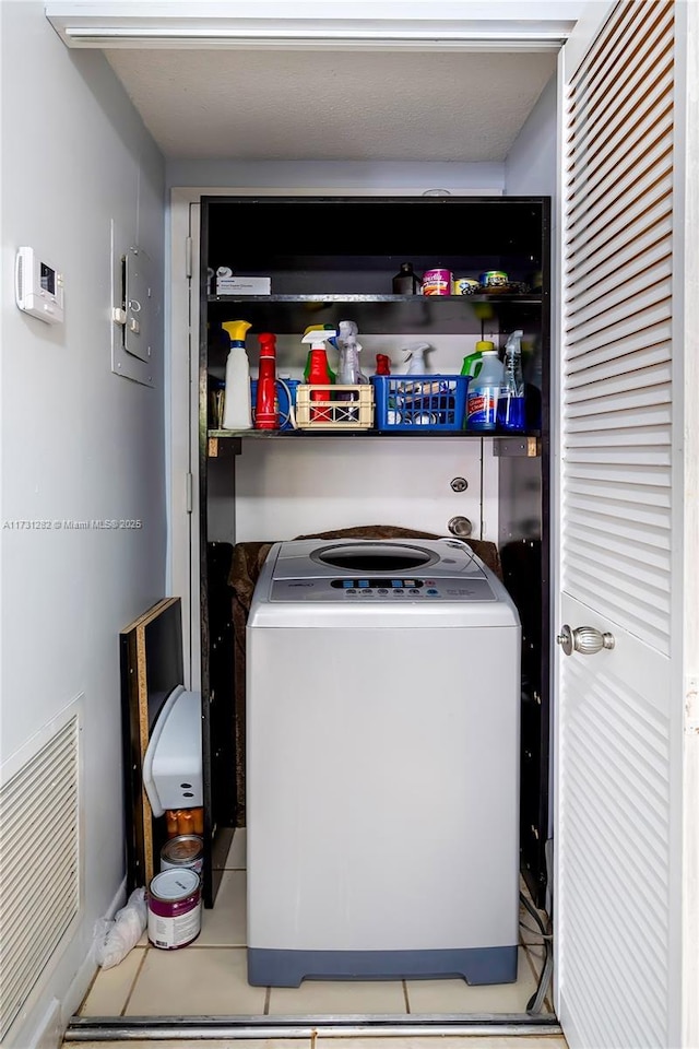 clothes washing area featuring washer / clothes dryer and light tile patterned floors