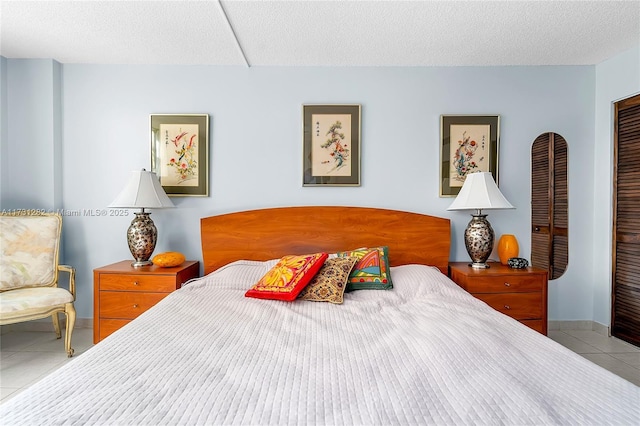 tiled bedroom featuring a closet and a textured ceiling