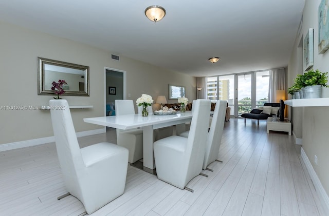 5601 Collins Ave Unit 420, Miami Beach, FL 33140 - dining area featuring a wall of windows and light wood-type flooring
