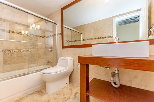 5601 Collins Ave Unit 420, Miami Beach, FL 33140 - full bathroom featuring enclosed tub / shower combo, sink, tile walls, and toilet