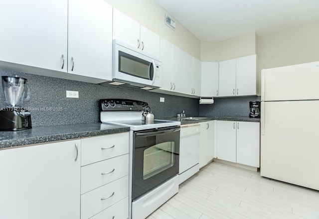 5601 Collins Ave Unit 420, Miami Beach, FL 33140 - kitchen featuring backsplash, white cabinets, and white appliances