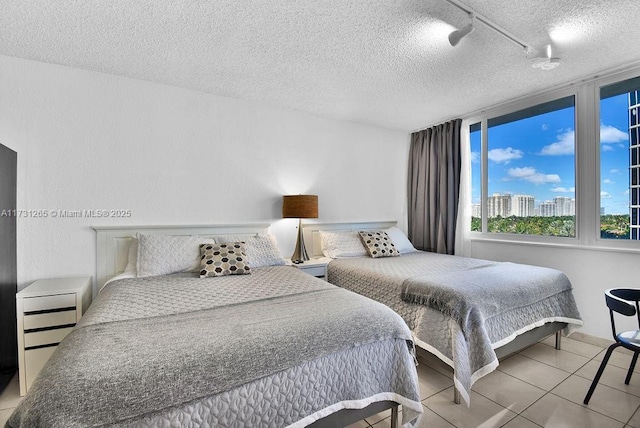 tiled bedroom with track lighting and a textured ceiling