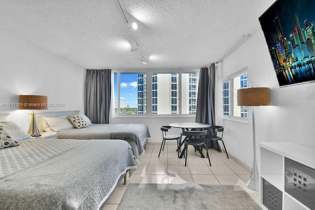 tiled bedroom with track lighting and a textured ceiling