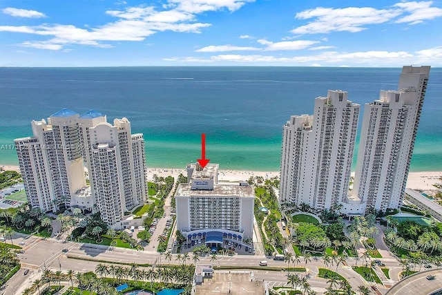 birds eye view of property featuring a water view and a beach view