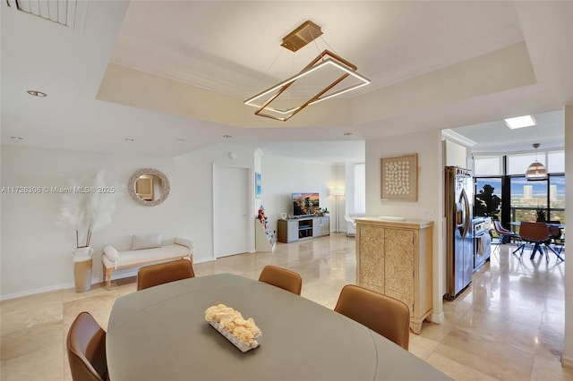 dining space featuring expansive windows and a tray ceiling