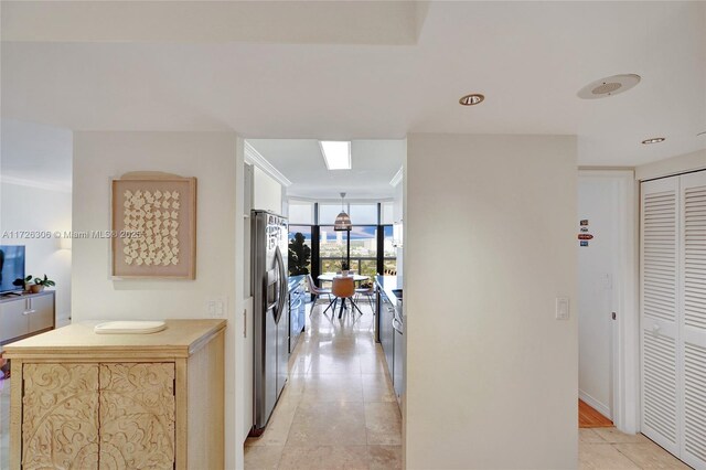 hallway with expansive windows and light tile patterned flooring