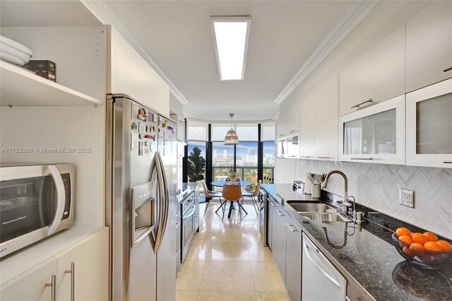 kitchen with stainless steel appliances, white cabinetry, sink, and crown molding