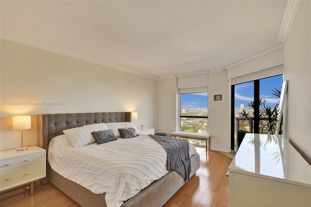 bedroom with crown molding, access to exterior, and light wood-type flooring